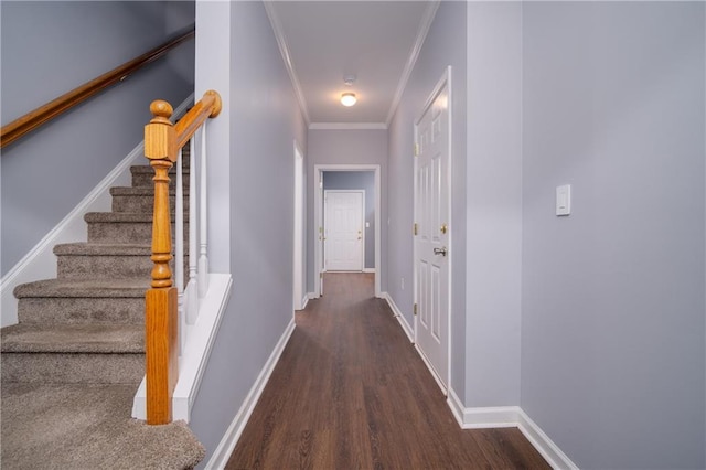 corridor featuring ornamental molding, stairs, baseboards, and wood finished floors