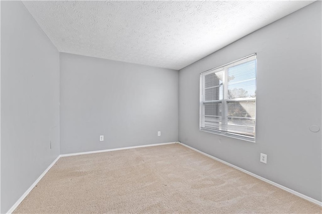 spare room with light colored carpet and a textured ceiling