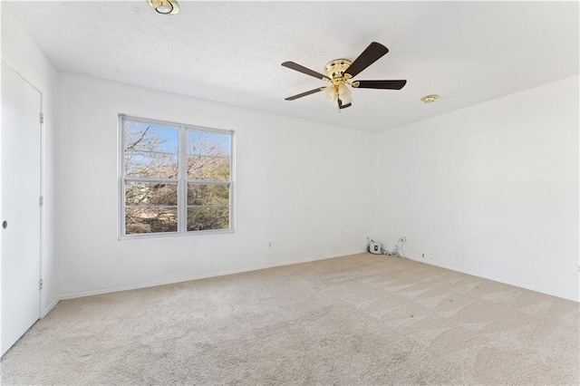 carpeted empty room with ceiling fan and a textured ceiling