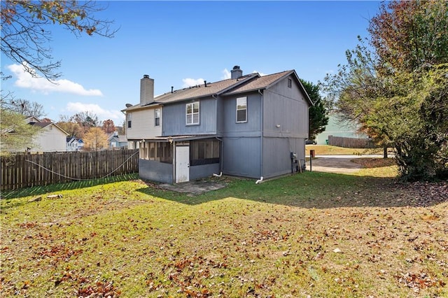 back of property featuring a yard and a sunroom