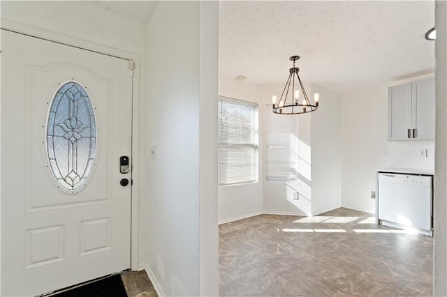 foyer entrance with a notable chandelier and a textured ceiling