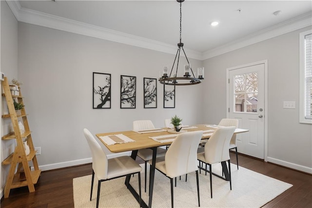 dining space featuring crown molding, dark wood-type flooring, and a chandelier