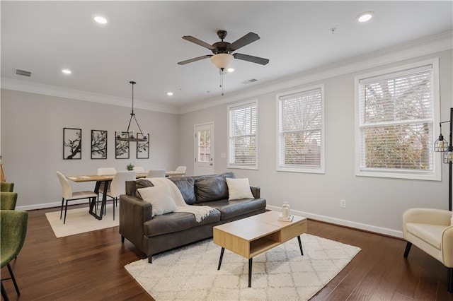 living room featuring crown molding, dark hardwood / wood-style flooring, and ceiling fan with notable chandelier