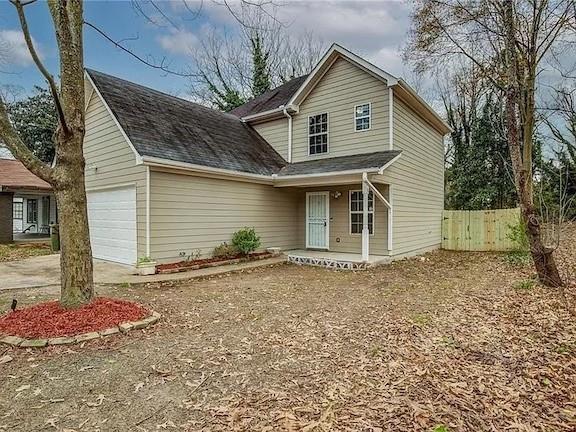 1526 Venetian Dr SW, Atlanta, GA 30311 - traditional home with driveway, covered porch, an attached garage, fence, and roof with shingles