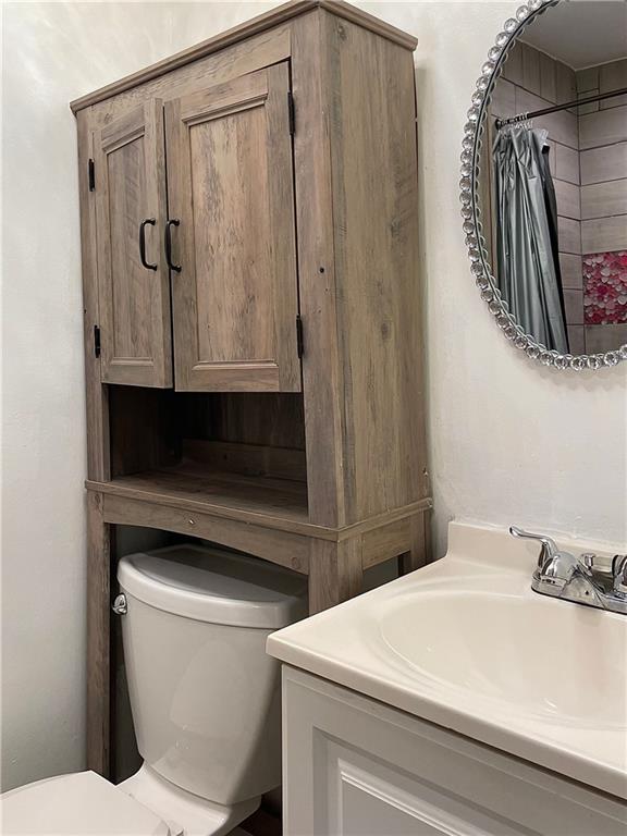 bathroom with a shower with curtain, vanity, and toilet