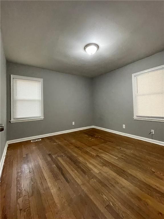 unfurnished room with dark hardwood / wood-style flooring