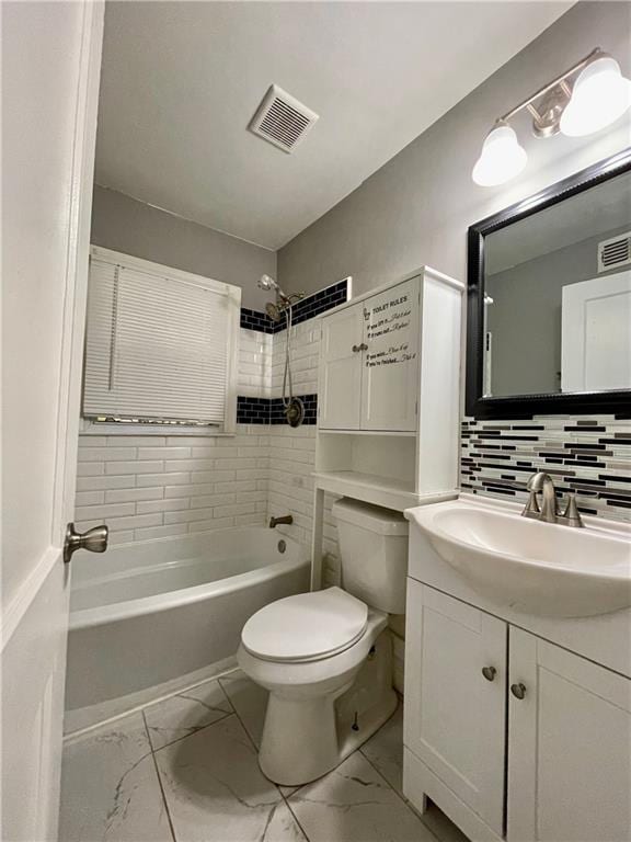 full bathroom with vanity, toilet, backsplash, and tiled shower / bath