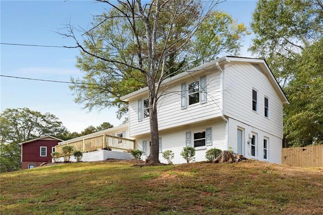 view of property exterior featuring a yard and a wooden deck