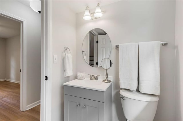 bathroom featuring vanity, wood-type flooring, and toilet