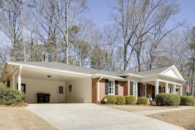 view of front facade with a carport, concrete driveway, and brick siding