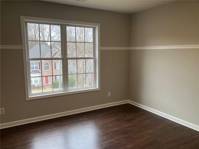 empty room with dark wood-type flooring and a wealth of natural light