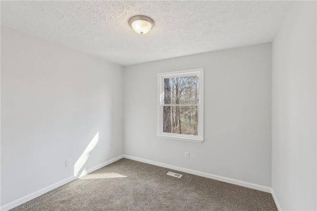 unfurnished room featuring carpet flooring and a textured ceiling