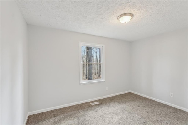 carpeted spare room with a textured ceiling