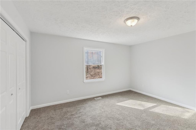 unfurnished bedroom featuring a closet, carpet, and a textured ceiling