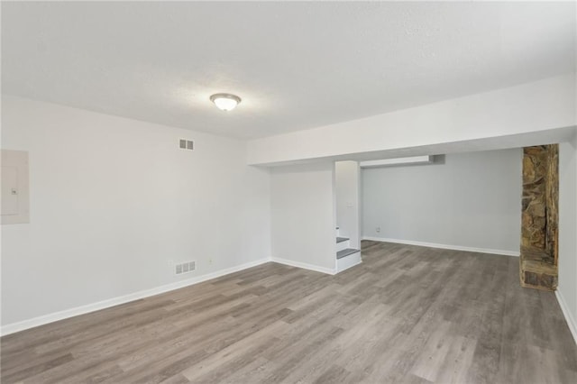 basement featuring hardwood / wood-style flooring and electric panel