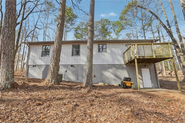 rear view of house with a wooden deck and cooling unit