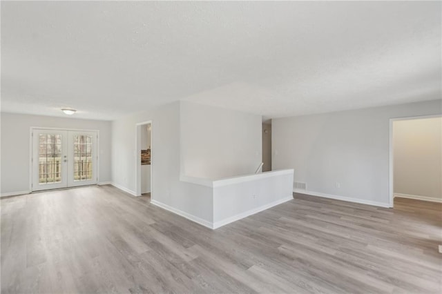 unfurnished room featuring french doors and light wood-type flooring