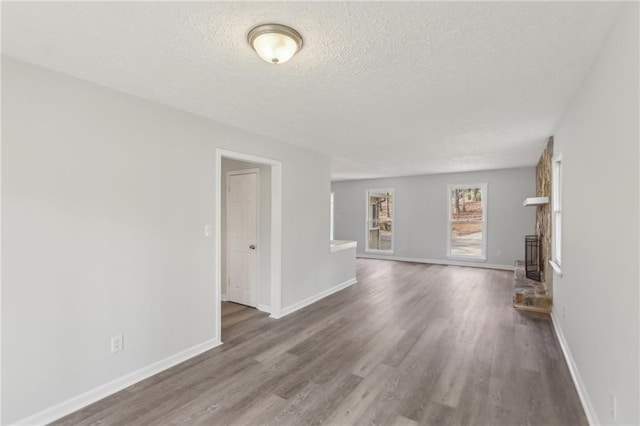 unfurnished living room featuring hardwood / wood-style floors and a textured ceiling