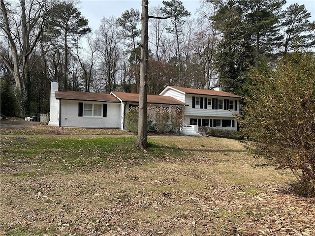 view of front facade with a chimney and a front yard