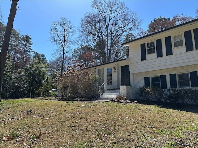 split level home with brick siding and a front yard