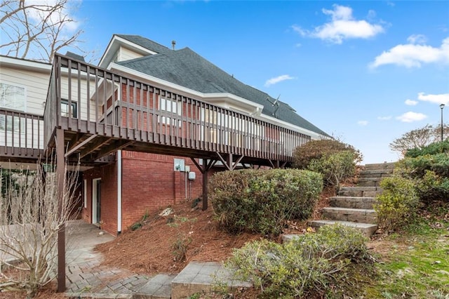 816 Ivy Ridge Dr, Loganville, GA 30052 - back of property with a deck, brick siding, stairway, and a shingled roof