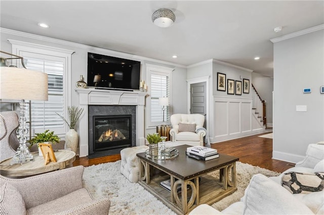 living room with ornamental molding, a high end fireplace, and dark hardwood / wood-style floors