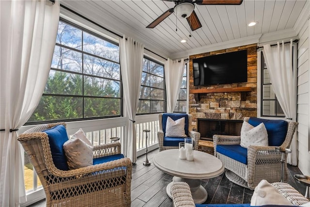 sunroom / solarium with a fireplace, ceiling fan, and wood ceiling