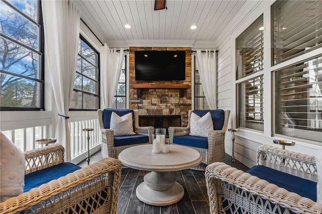 sunroom with wood ceiling and a fireplace