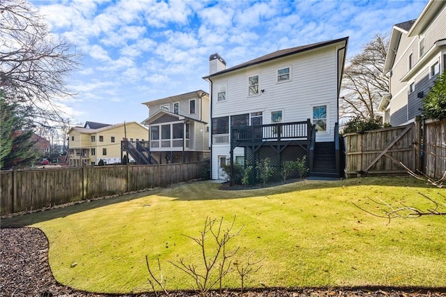 back of house featuring a deck and a lawn