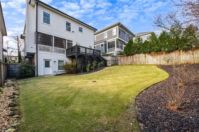 rear view of house with a yard and a wooden deck