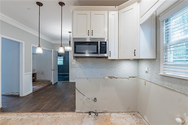 402 John Tate Rd NW, Acworth, GA 30102 - kitchen with stainless steel microwave, crown molding, white cabinetry, dark wood finished floors, and decorative light fixtures