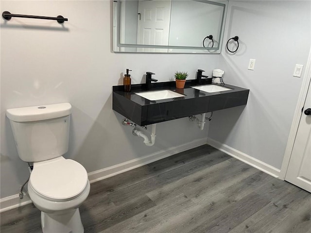 257 E Simon Ter NW, Atlanta, GA 30318 - bathroom featuring a sink, baseboards, toilet, and wood finished floors
