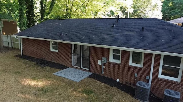 257 E Simon Ter NW, Atlanta, GA 30318 - rear view of property with central air condition unit, brick siding, fence, and roof with shingles