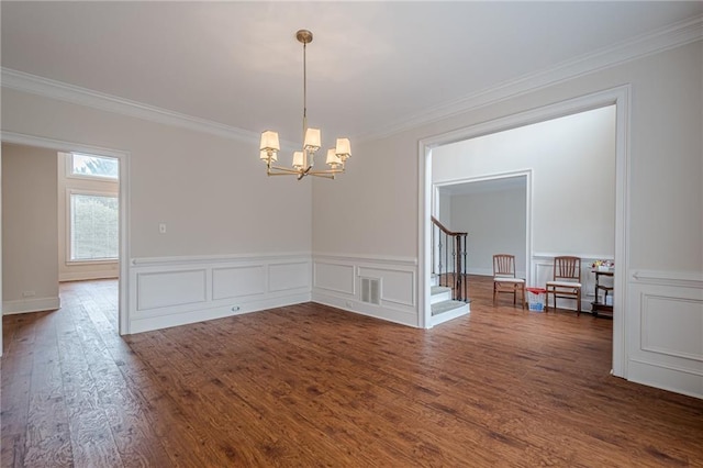 unfurnished room with dark wood-type flooring, ornamental molding, and a chandelier