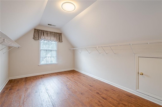 walk in closet with hardwood / wood-style flooring and lofted ceiling