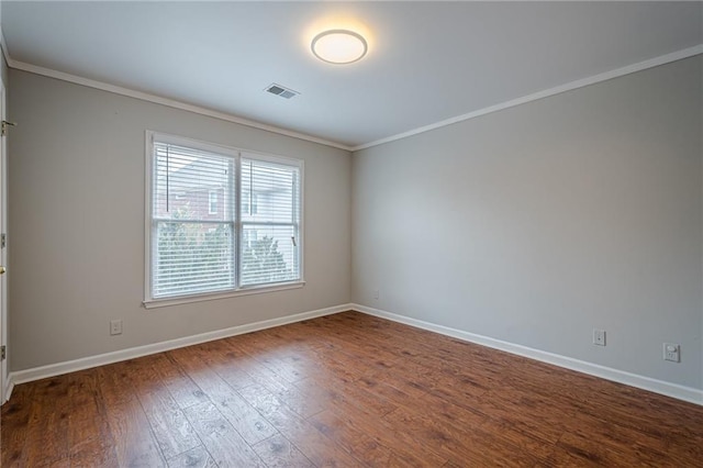 spare room with ornamental molding and dark hardwood / wood-style floors