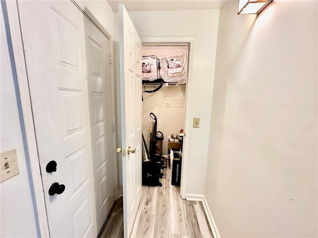 hallway with light hardwood / wood-style floors