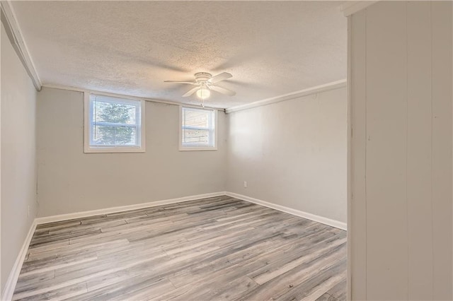 spare room with crown molding, ceiling fan, light hardwood / wood-style floors, and a textured ceiling