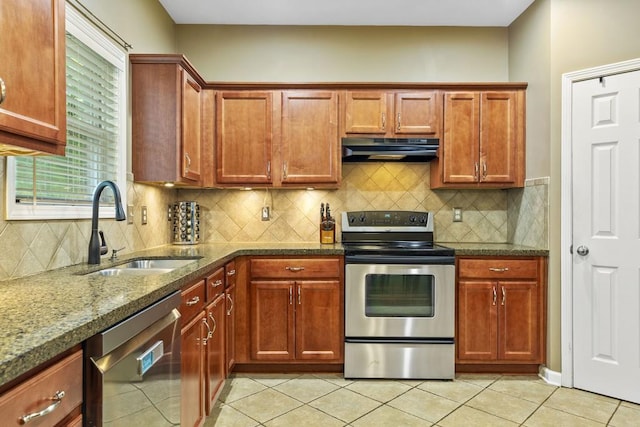 kitchen featuring stainless steel range with electric cooktop, dishwasher, under cabinet range hood, a sink, and light tile patterned flooring