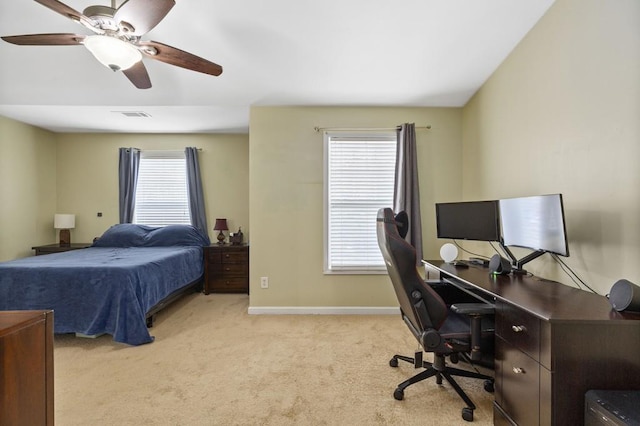 bedroom with light colored carpet, a desk, baseboards, and ceiling fan