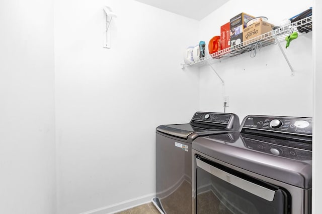 laundry area featuring independent washer and dryer, tile patterned flooring, and baseboards
