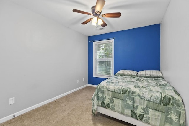 carpeted bedroom featuring baseboards and a ceiling fan