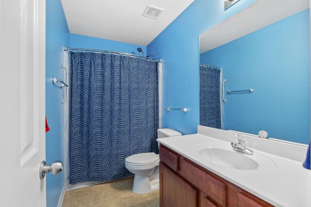 full bathroom featuring toilet, vanity, a shower with shower curtain, and tile patterned floors