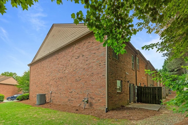 view of home's exterior with central AC unit and brick siding