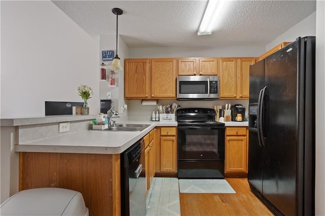 210 Cottonwood Creek Cir, Canton, GA 30114 - kitchen featuring black appliances, a sink, a peninsula, light countertops, and a textured ceiling