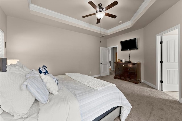 carpeted bedroom featuring a raised ceiling, ornamental molding, and baseboards