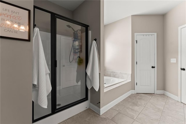 bathroom with baseboards, a stall shower, and a garden tub