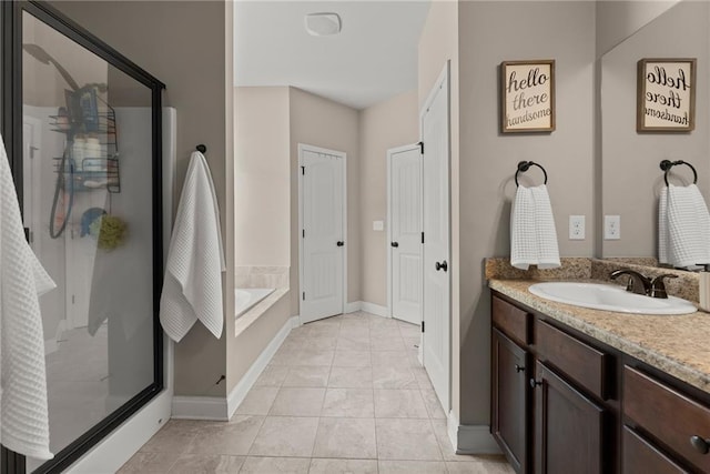 full bath featuring vanity, baseboards, a bath, and a stall shower