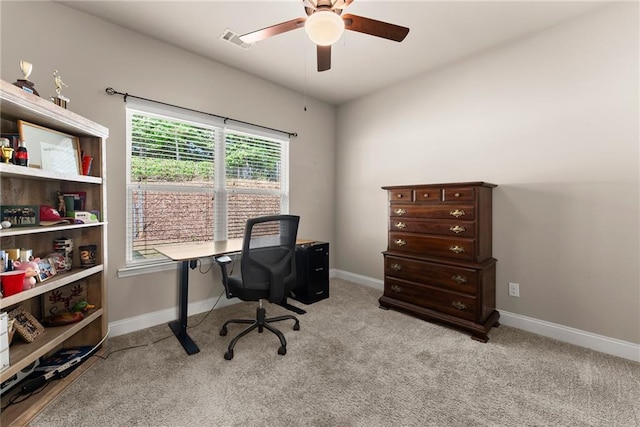 home office featuring baseboards, ceiling fan, visible vents, and light carpet