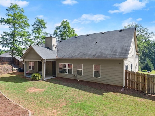 back of house featuring a lawn, a fenced backyard, a patio area, and a chimney